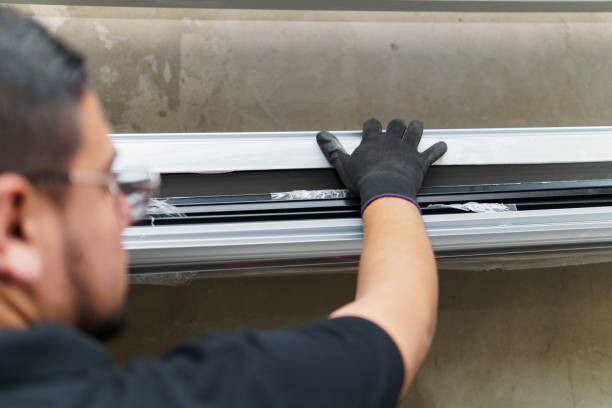 A professional installer working on a large window.